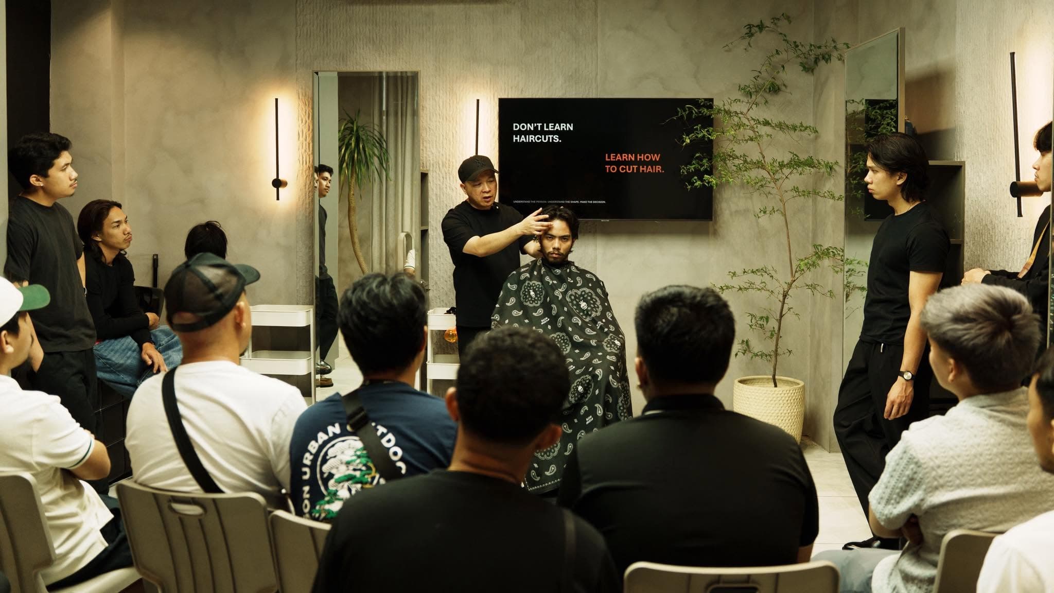 A PARE Education class watching a live haircut demonstration